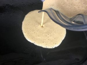 adding the pancake batter to the hot cast-iron griddle